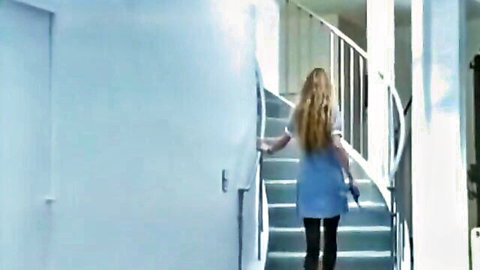 Blonde woman in blue dress and stockings walks up stairs in 80s European hospital porn