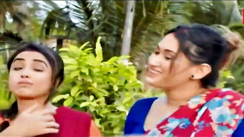 Two seductive Indian women in colorful sarees posing in lush garden