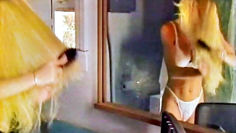 Skinny blonde in white bra and thong brushing long hair in mirror