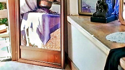 Vintage retro room interior with purple draped table, copper pot, mirror and bronze statue