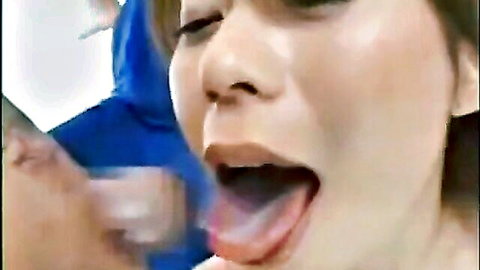 Close-up of Japanese woman with mouth open wide, tongue out in cumshot scene