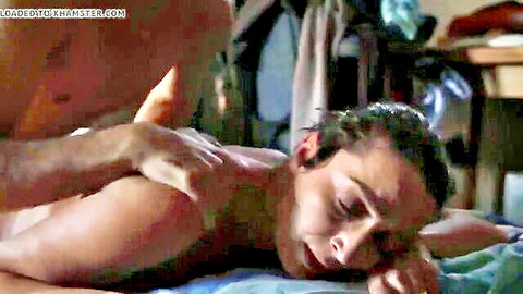 Muscular man giving sensual back massage to fit shirtless guy on bed
