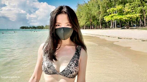 Sexy East Asian babe in leopard bikini top and mask teasing huge cleavage on sunny beach