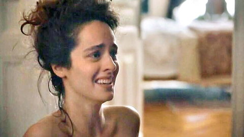 Topless brunette with bare tits smiling through tears in luxurious room