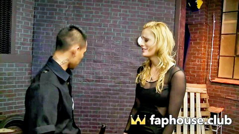 Blonde in sheer black mesh top showing tits flirts with tattooed guy in brick room