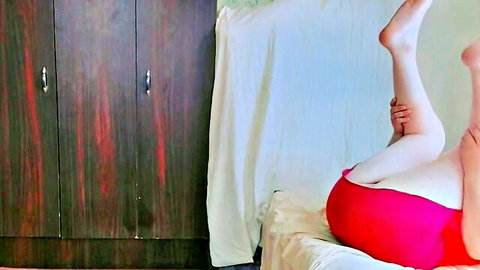 Playful trans hottie lifting leg to show thigh tattoo in short red petticoat