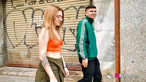 Blonde Lorena in orange bralette and skirt with guy outdoors, teasing shaved pussy
