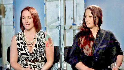 Two redhead women in interview, one in black and white dress with tattoo