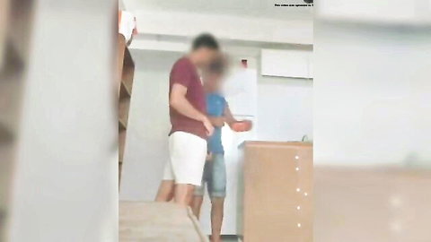 Two mature men in shorts and tees touching intimately at home