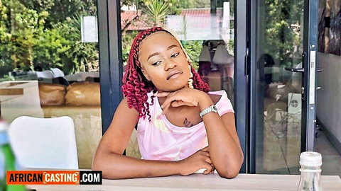 Curly-haired ebony teen in pink top posing thoughtfully for casting