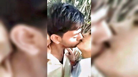Young Desi gay couple passionately kissing outdoors in white shirt