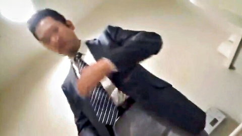 Mature Asian man in dark suit adjusting tie, business tease