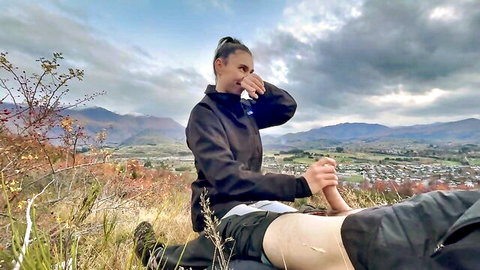 Brunette hiker in shorts outdoors, teasing blowjob in mountains