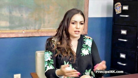 Curvy Latina teacher in floral top gesturing in office