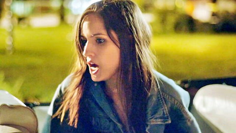 Asta Paredes in denim jacket, mouth open, outdoor night scene from Return to Nuke 'Em High Vol 1