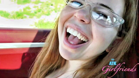 Young brunette girlfriend laughing with wide smile in car POV