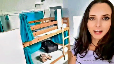 Marissa smiling in hostel room, teasing OnlyFans content