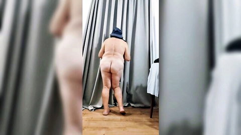 Nude mature woman in hat bending over, exposing ass from behind