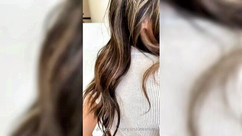 Morgan Alexandra with long wavy highlighted hair in striped top, teasing view