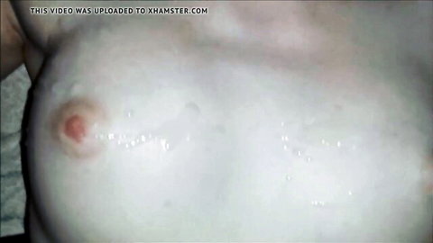 Close-up of pale woman's breast with semen dripping from pink nipple after threesome cumshot