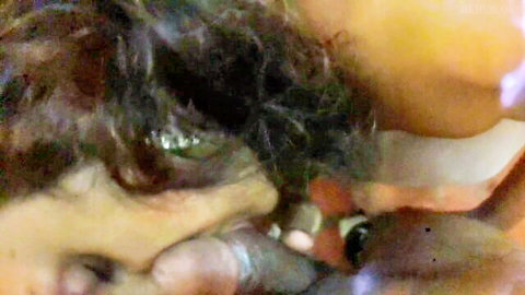 Close-up of brunette woman with messy hair in explicit oral scene