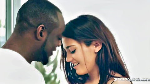 Intimate interracial couple forehead touch, black man and brunette woman smiling passionately