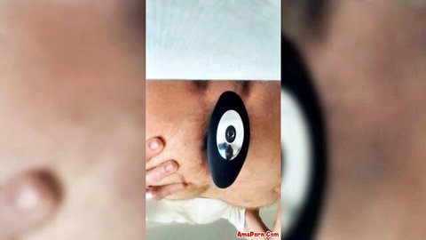Blurry closeup of black anal plug inserted deep in pale shaved asshole