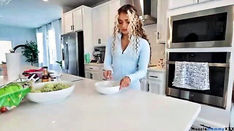 Curly-haired fit woman in tight blue zip-up outfit cooking healthy meal