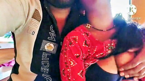 Bearded man hugs curvy Indian woman in red embroidered blouse, deep cleavage