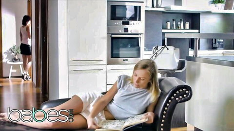Vicky Love lounging in tank top and shorts with Aislin in kitchen