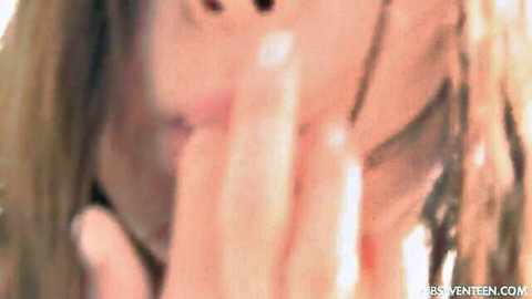 Lily G close-up tease with blonde hair and seductive hand gesture