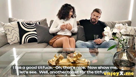 Curly-haired brunette in tight top and mini skirt toasts glasses with bearded guy on couch teasing titfuck