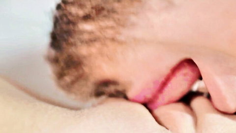 Bearded man with curly hair licking pale woman's nipple in close-up after intense cunnilingus