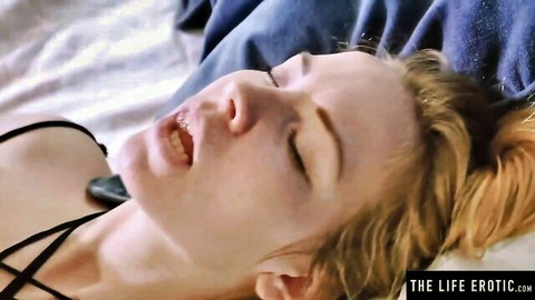 Blonde woman in lingerie experiencing intense pleasure from strap-on play