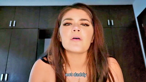 Seductive brunette woman in black top with 'not daddy' overlay teases viewer
