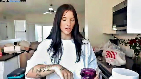 Tattooed brunette in oversized white shirt in casual kitchen vlog haul