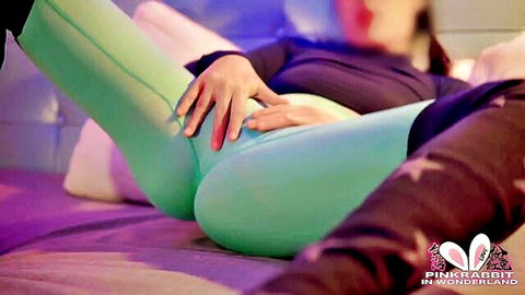 Asian fitness babe in tight green leggings, hands on crotch, seductive pose