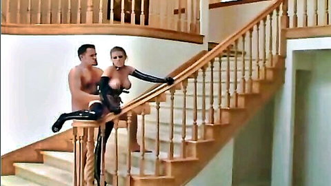 Busty blonde Stiletto in latex stockings and corset bent over stairs