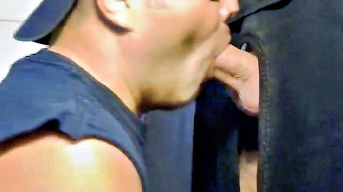 Asian man in tank top and cap puckers lips to suck cock through glory hole