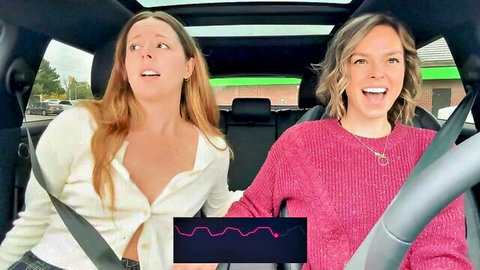 Shocked busty brunette with big tits cleavage reacts to remote vibrator in car while blonde grins