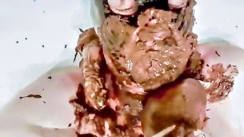 Close-up of messy raw meat pile with pink globs and sauce dripping on white plate