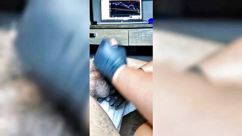 Wife in blue gloves gives tugjob to stressed husband at desk
