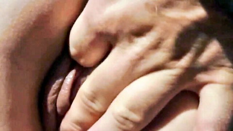 Man's fingers spreading and fingering wet pink pussy lips closeup