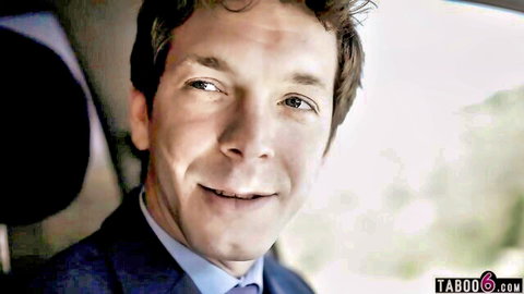 Handsome suited brunette man smiling seductively in car for taboo porn