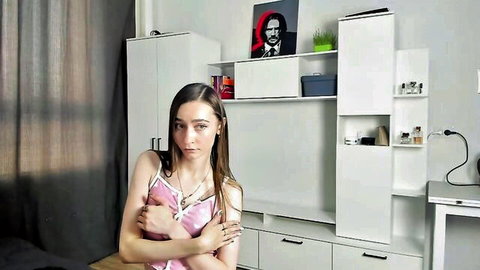 Petite skinny teen webcam girl in pink camisole crosses arms over tits teasing seductively