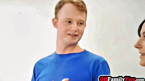 Young redhead guy in blue shirt chatting with brunette woman in kinky family swap preview, max 100 chars
