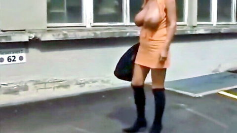 Mature German woman exposing huge breasts in orange mini dress and stockings outdoors