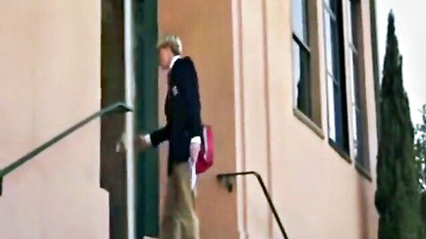 Blonde woman in school uniform entering classroom after school
