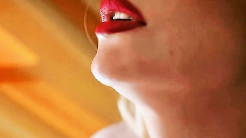Seductive close-up of blonde woman's red lips smiling in peignoir, JOI tease
