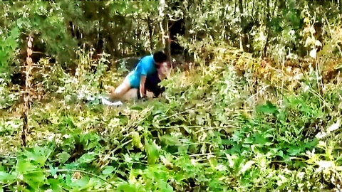 Hunky guy exposing ass in outdoor forest bushes, pants down squatting